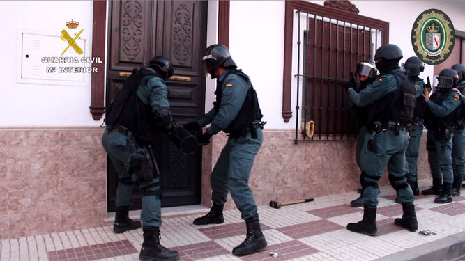 Los agentes del Instituto Armado abren la puerta de acceso a la casa almonteña con un ariete.
